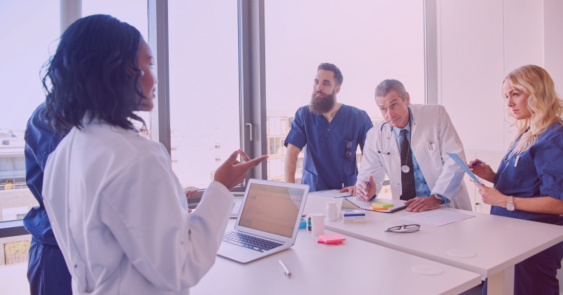 medical practitioners consulting around a table